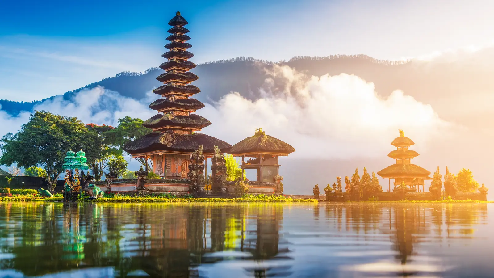 Đền Ulun Danu Beratan với các tầng mái chồng lên nhau bên hồ ở Bali, mây phủ núi phía sau.