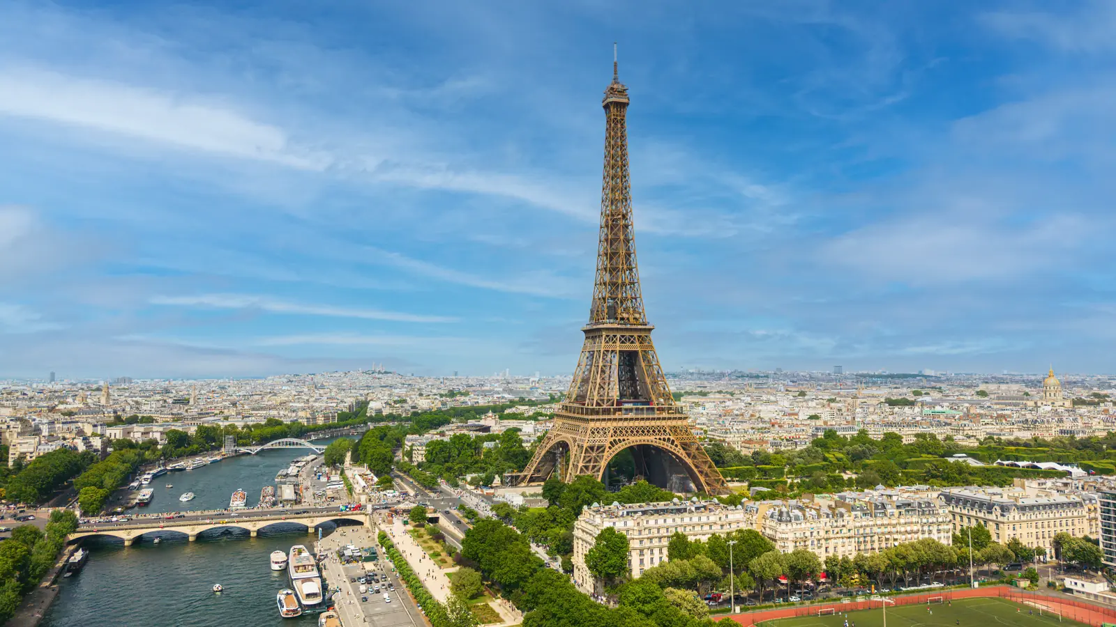 The Eiffel Tower and the Seine from above, Paris stretching to the horizon.