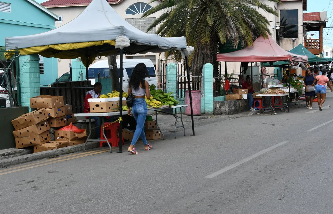A street market in St John's, Antigua, with stalls of produce along the roadside.
