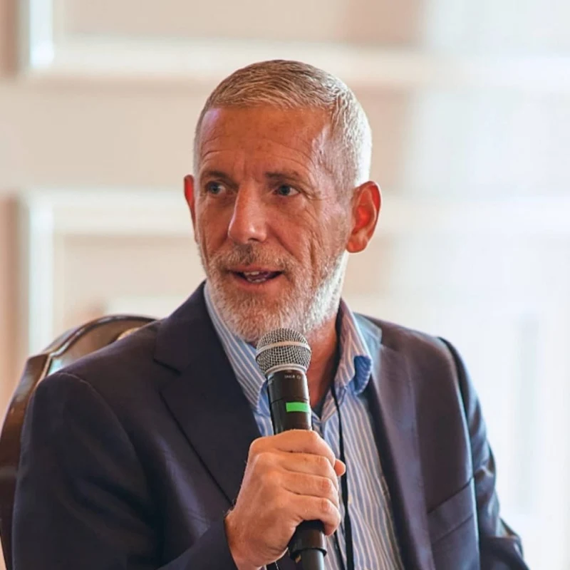 Aran Hawker speaking into a microphone at a conference