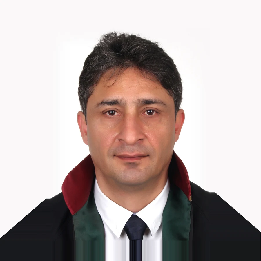 Portrait of attorney Murat Yüksel in a black lawyer's robe with red and green collar, white shirt and dark tie