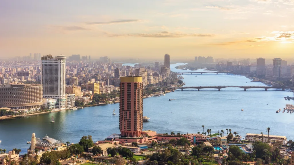 Downtown Cairo on the Nile at sunset, with the Cairo Tower district in the foreground and bridges across the river.
