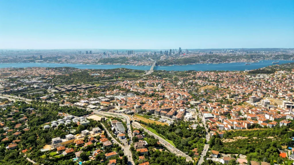 An aerial view of a residential area of Istanbul, low-rise housing in the foreground and the Bosphorus and city skyline behind.