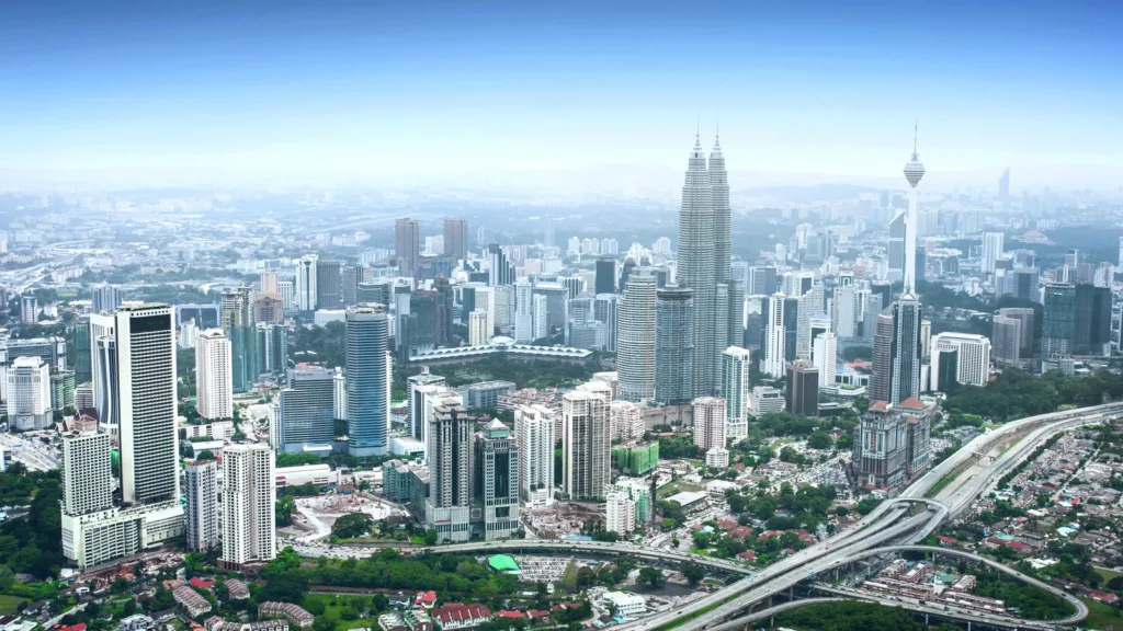 Kuala Lumpur ban ngày nhìn từ trên cao, với Tháp đôi Petronas, một tháp viễn thông và các tuyến cao tốc xuyên thành phố.