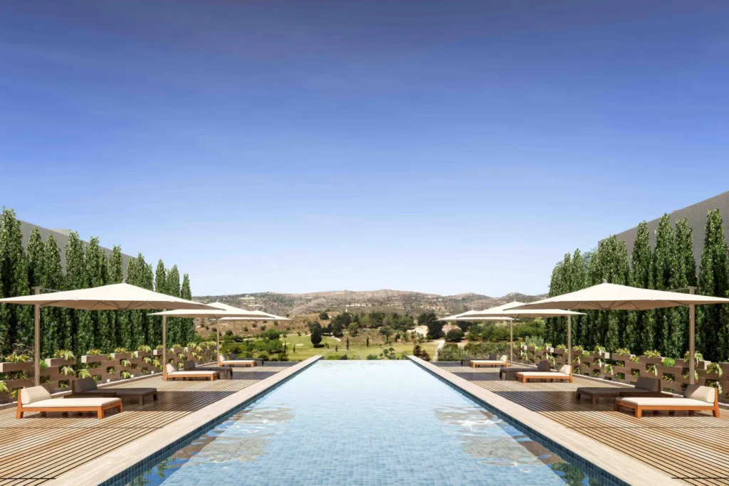 Outdoor lap pool with umbrellas and a cypress hedge