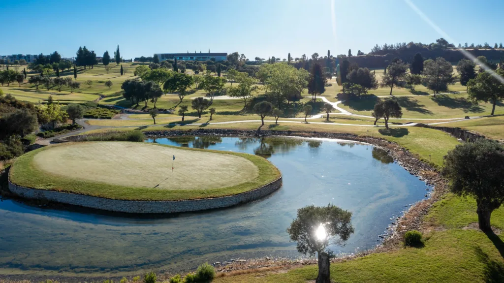 A golf green set in a lake with a fountain