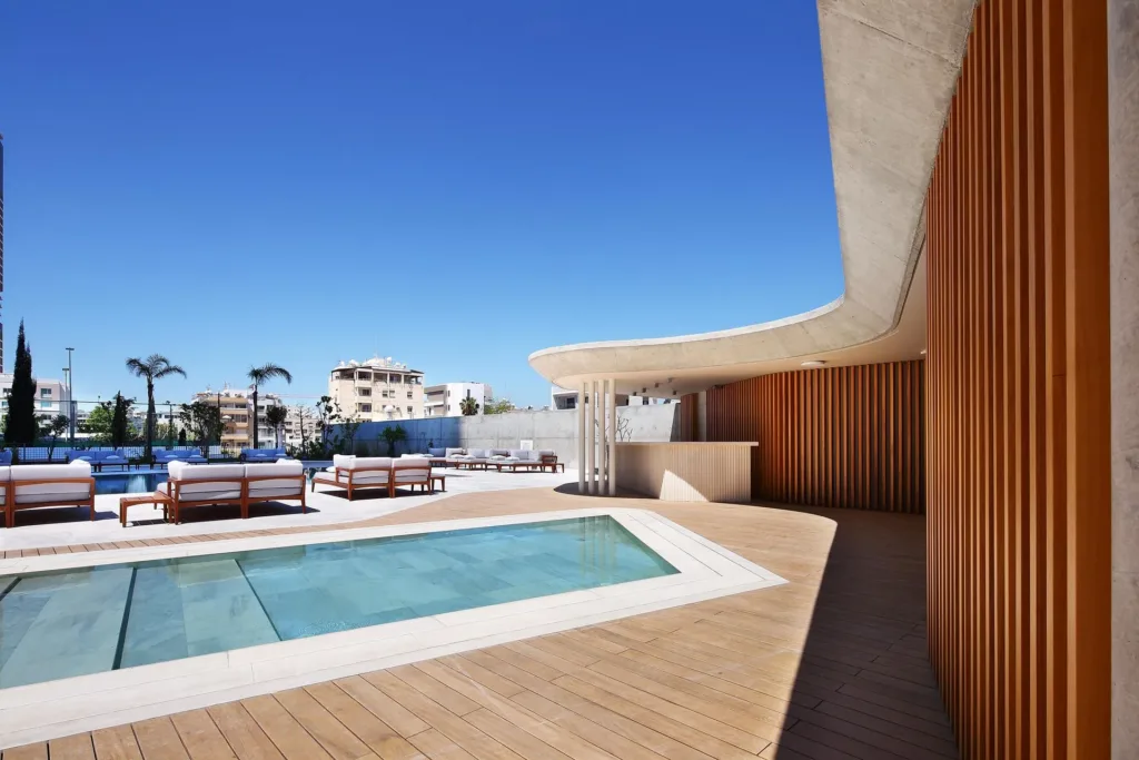Pool and sun loungers on the ONE terrace beside timber screens