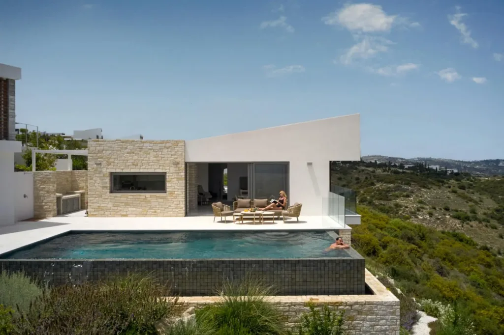 Hillside villa with an infinity pool and stone-clad terrace overlooking green valleys
