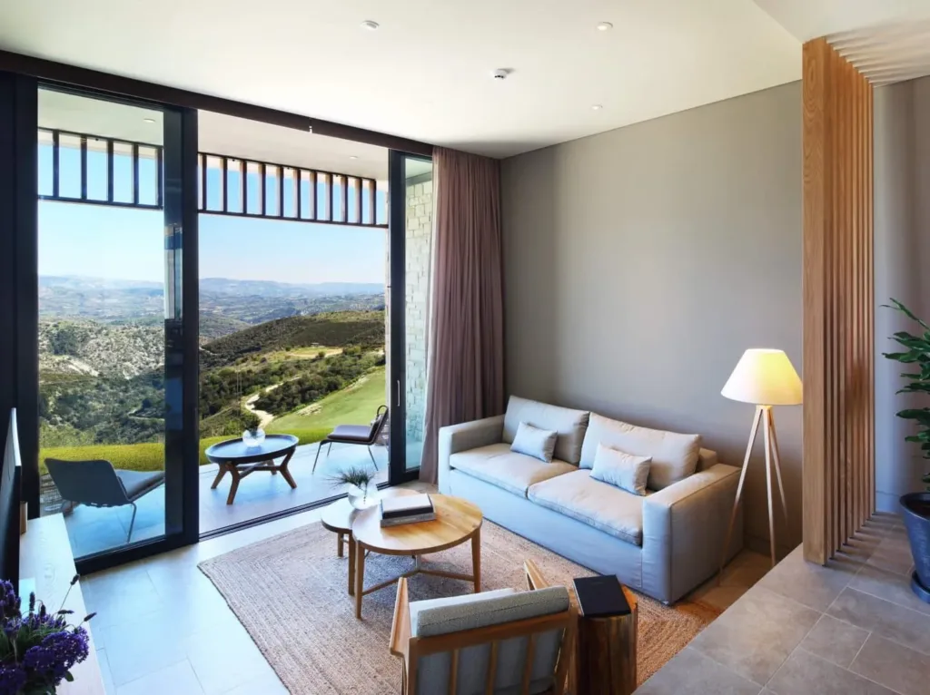 Living room with sliding doors opening onto a terrace and hill views