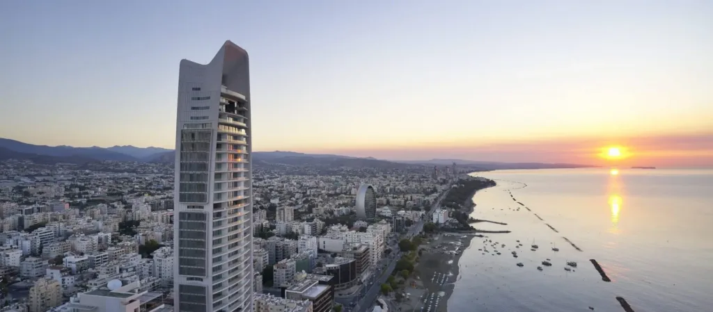 The ONE tower at sunset with the Limassol coastline stretching towards the sun