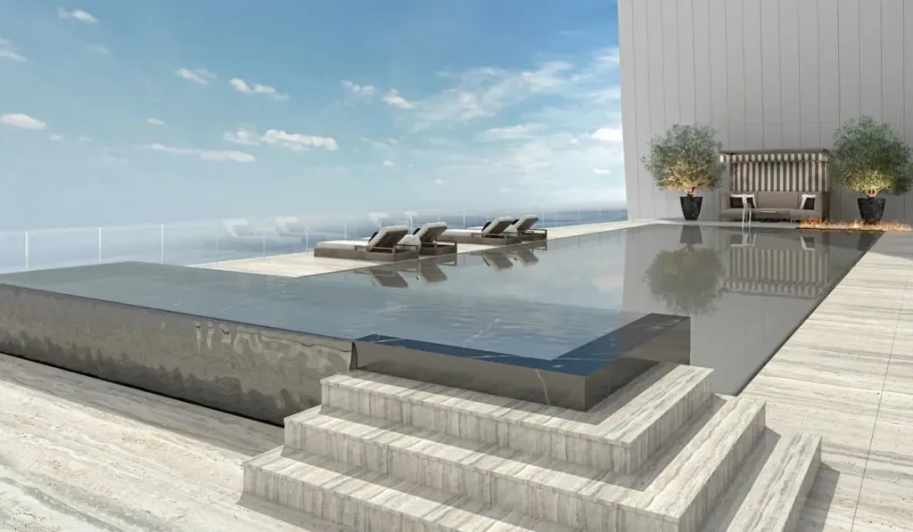Penthouse roof terrace with an infinity pool, stone steps and loungers facing the sea