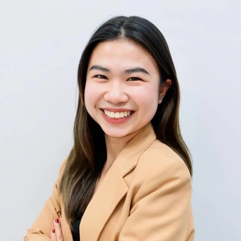 Chân dung bà Tinee Nguyen tóc dài, mặc áo vest màu be, khoanh tay mỉm cười trên nền sáng