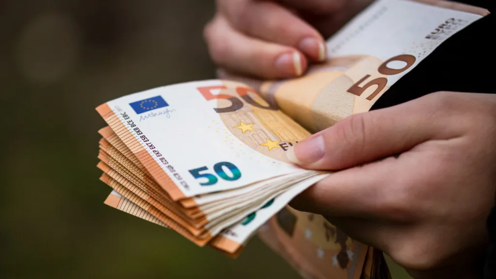 Hai bàn tay đếm một xấp tờ tiền 50 euro