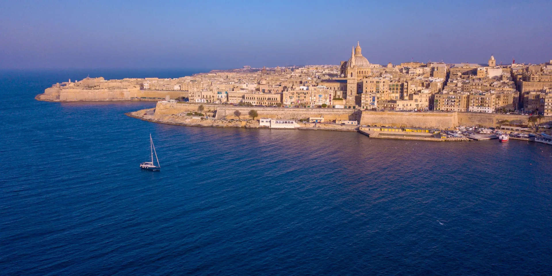 Aerial view of the Valletta peninsula, with a church dome and the seafront fortifications